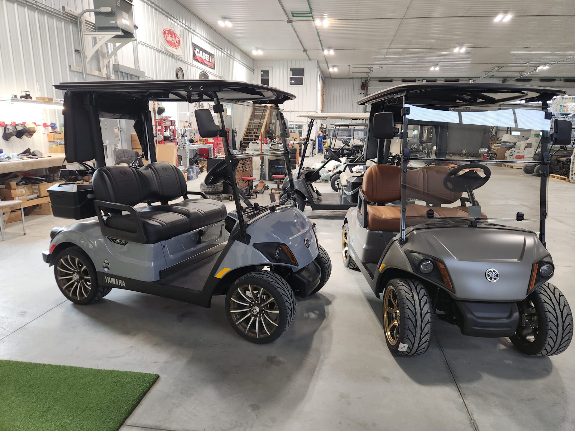 Two 2027 Yamaha Drive2 carts side by side inside the Road Fiftynine shop
