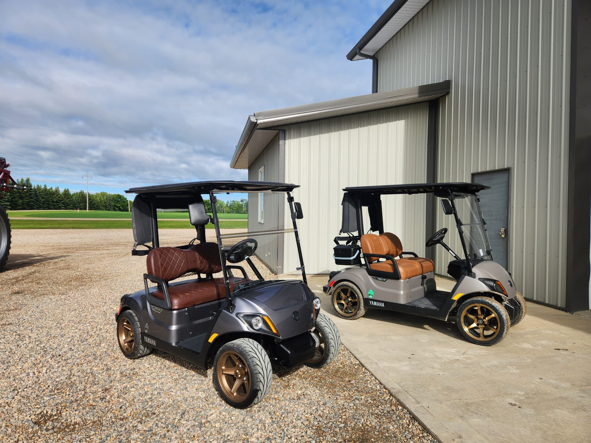 Two custom Yamaha carts parked outside the shop
