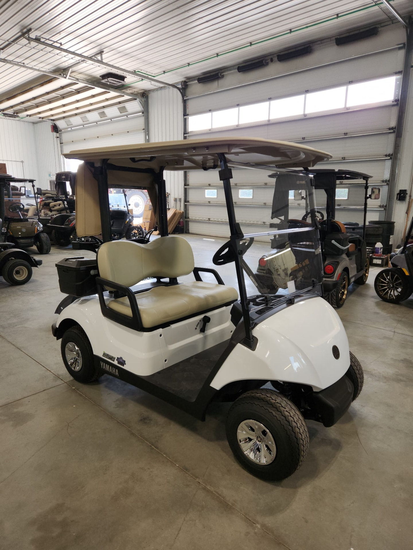 White Yamaha cart with tan seats inside the shop